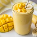 Creamy banana mango smoothie in sunlight