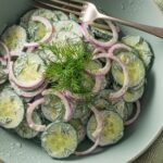 chilled creamy cucumber salad in ceramic bowl
