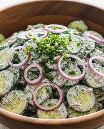 high protein cucumber salad in wooden bowl with dill and red onion