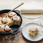 slicing sourdough discard cinnamon roll dough on floured counter