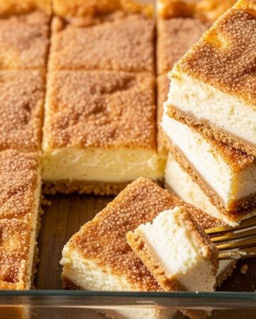 sliced churro cheesecake bars with golden cinnamon topping